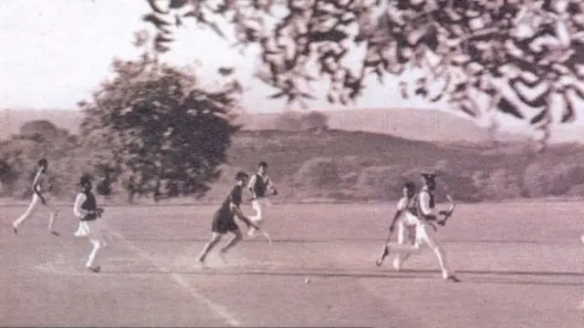 काली जर्सी में हॉकी खेलती हुईं आबिदा सुलतान