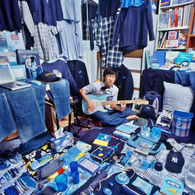 A boy surrounded with his blue belongings.