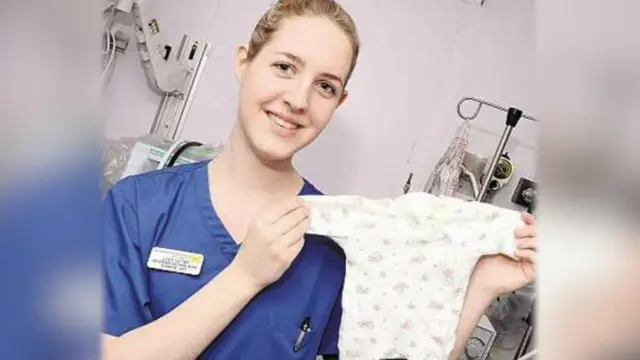 Lucy Letby segura roupinhaesporte da sorte foguetebebê e posa para foto no hospital onde trabalhava