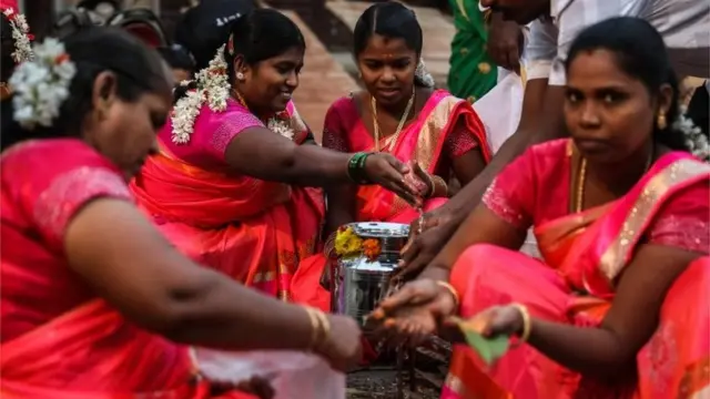 Tamilian women cook pongal, a traditional rice dish, during the Thai Pongal festival celebration in Mumbai, India, 15 January 2020