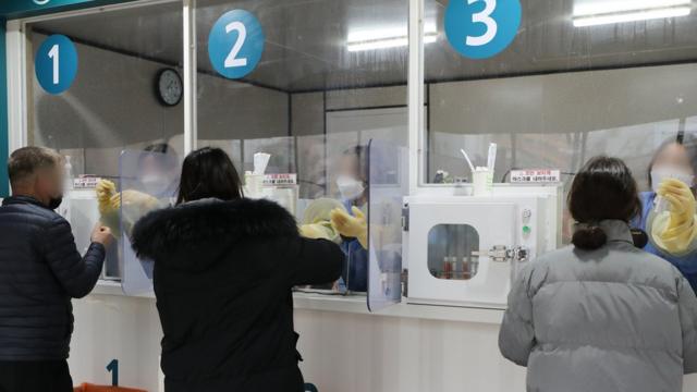 신규확진자 수가 8571명을 기록하며 처음으로 8000명을 넘어선 25일 서울 서대문구 독립문광장에 마련된 코로나19 검사소에서 시민들이 검체 검사를 받고 있다