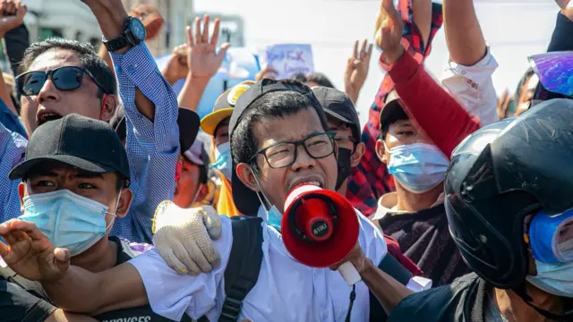 Protesters shout slogans through a megaphone at the junction