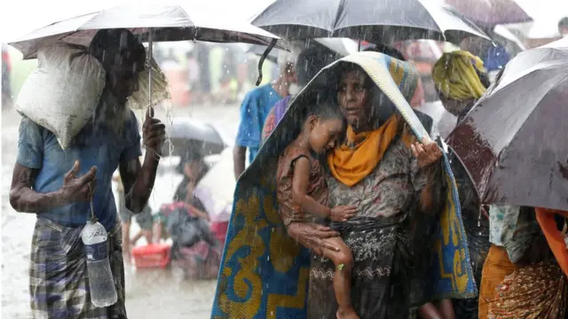 Rohingya refugees stands in an open place during heavy rain, as they are hold by Border Guard Bangladesh (BGB) after illegally crossing the border, in Teknaf, Bangladesh,