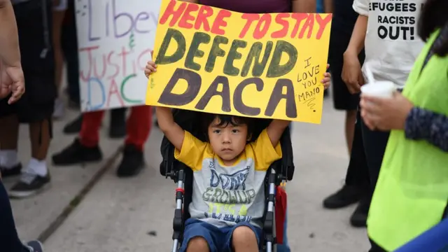 Un niño con un cartel que dice "Aquí para defender el Daca", en una protesta en California.
