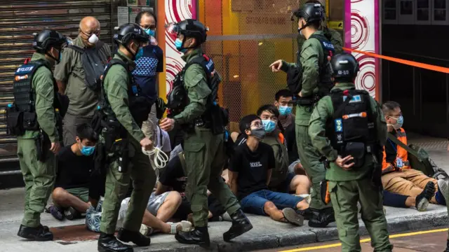 Jovens manifestantes detidos sentados no chão cercados por policiaisroleta green bet365Hong Kong