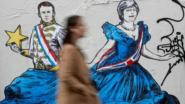 Paris'te Fransa Cumhurbaşkanı Macron ve İngiltere Başbakanı May'i elele gösteren bir duvar resmi.