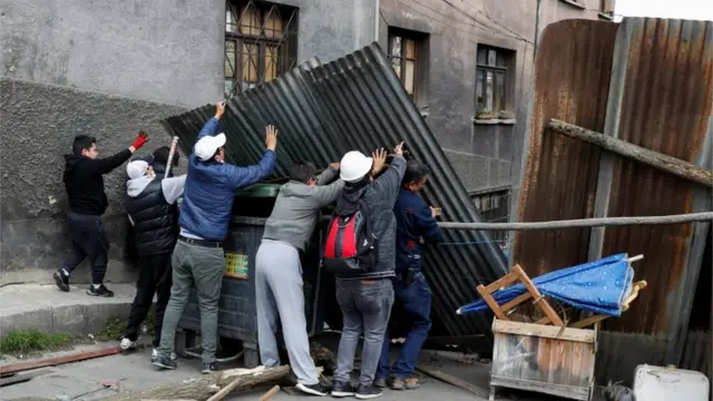 Un grupo de personas coloca barricadas para cerrar los accesos a la céntrica plaza Murillo, en torno a la cual tienen su sede los poderes del estado en La Paz.
