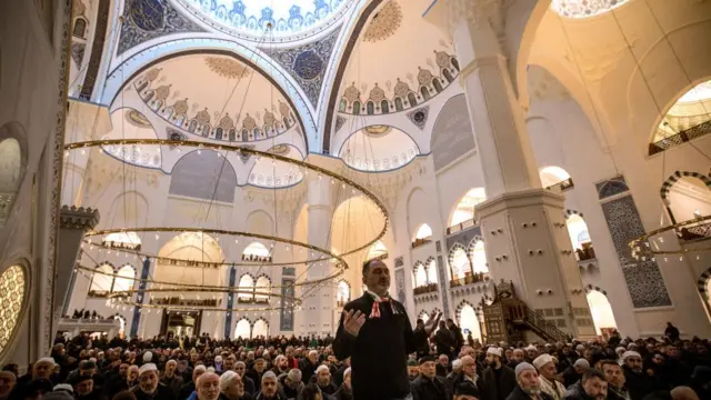 أحد المصلين يقف ويرفع يديه بالدعاء