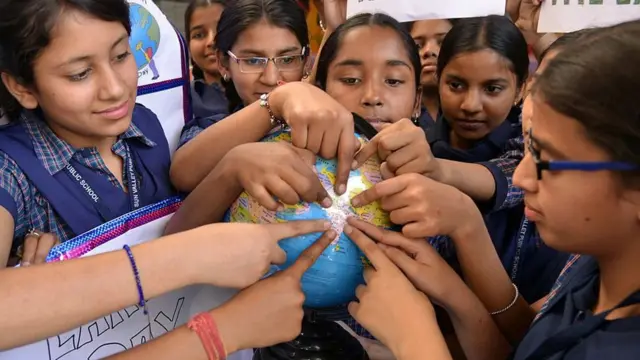 ప్రపంచ పటంలో భారతదేశాన్ని చూపిస్తున్న చిన్నారులు