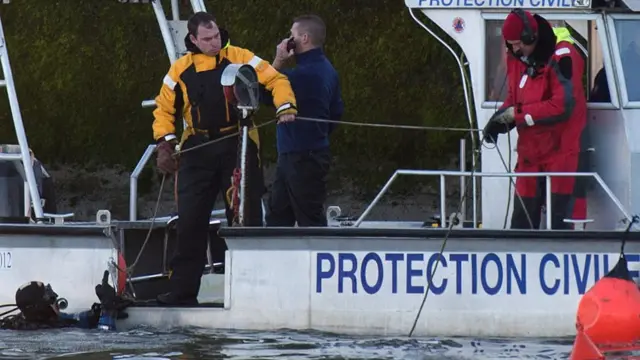 Agentes de protección civil belgas en el rio Mosa