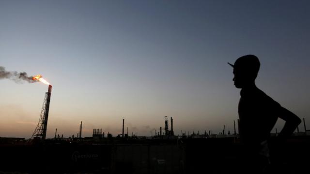 A man stands to a state-owned refinery in Western Venezuela (2016)