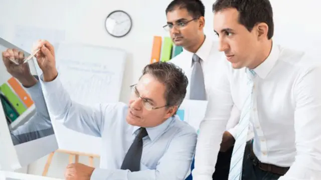 Empresarios mirando una pantalla.