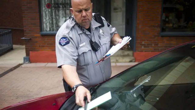 Policial multa carro estacionado