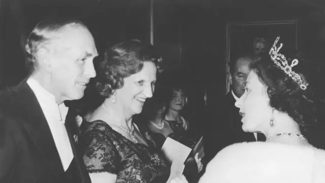 1964年，女王在一次宴会上与首相阿勒克·道格拉斯-霍姆及夫人说话。