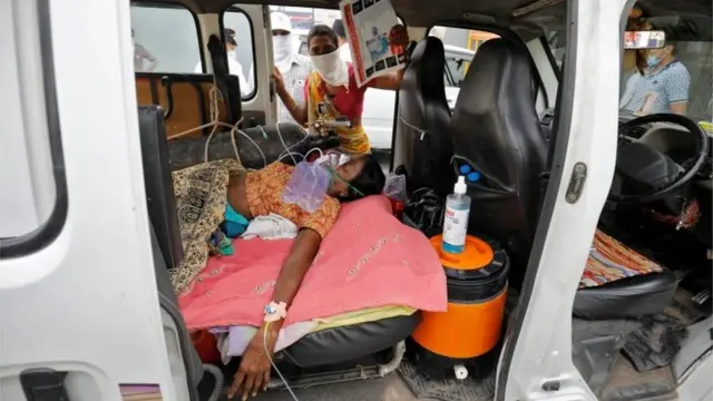 A patient wearing an oxygen mask is seen inside a car waiting to enter a COVID-19 hospital for treatment, amidst the spread of the coronavirus disease (COVID-19) in Ahmedabad, India, April 26, 2021