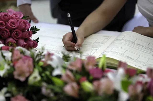 Mujer firmando acta de matrimonio.
