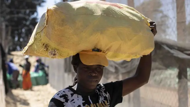 Woman carrying grain bag