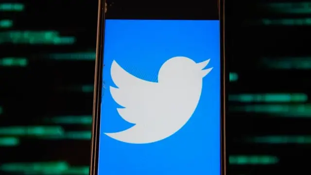 The Twitter logo on a mobile phone screen