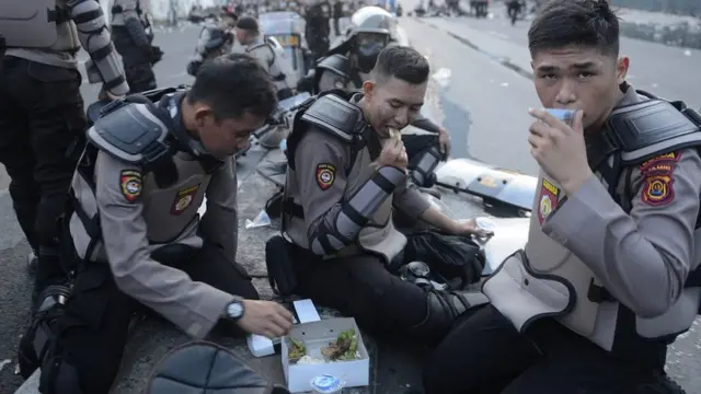 Polisi yang tengah bertugas berbuka puasa.
