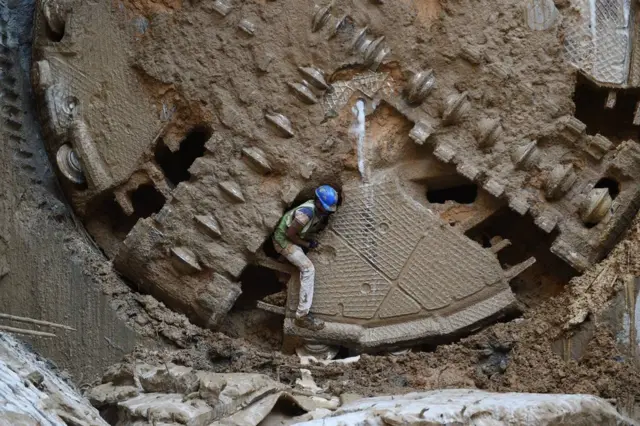 ਗੁਜਰਾਤ ਦੀ ਰਾਜਧਾਨੀ ਅਹਿਮਦਾਬਾਦ ਵਿੱਚ ਇੱਕ ਮਜ਼ਦੂਰ ਇੱਕ ਸੁਰੰਗ ਪੱਟਣ ਵਾਲੀ ਬੋਰਿੰਗ ਮਸ਼ੀਨ ਵਿੱਚ ਨਿਕਲਦਾ ਹੋਇਆ।