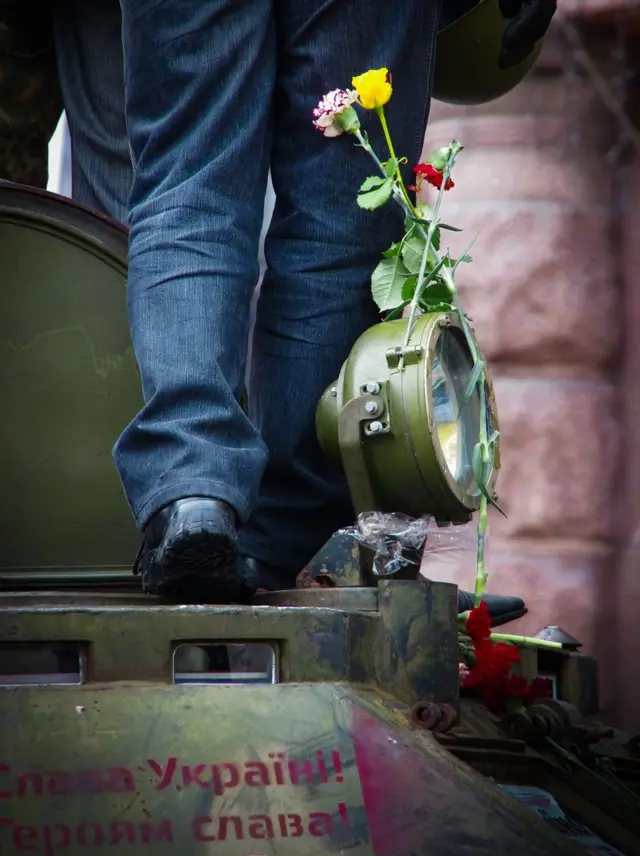 Людина з каскою біля квітів