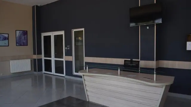 В отремонтированном новом корпусе светлая приемная для посетителей. На стенах фотографии старого здания