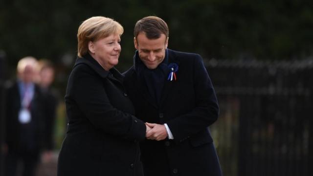 Germany's Angela Merkel and France's Emmanuel Macron embrace in the clearing of Rethondes in Compiegne