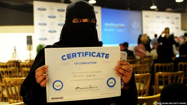 A Saudi woman poses for a photo with a certificate after completing a driving course in Jeddah on March 7, 2018