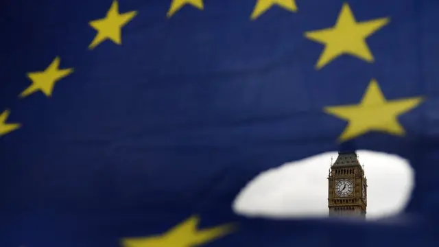 Bandeira da UE com furo mostrando o Parlamento Britânico