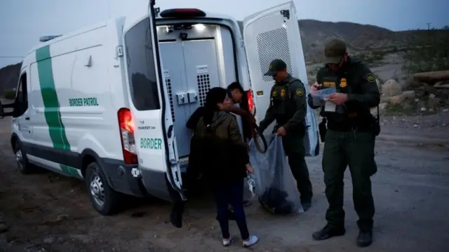 Agentes de la patrulla fronteriza y un migrante