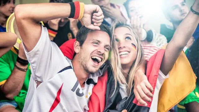 Dos alemanes en un partido de fútbol, aupando a su equipo