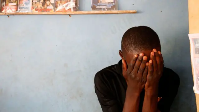 Un jeune homme cachant son visage