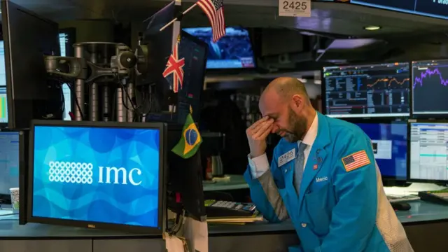 Seorang broker di New York Stock Exchange khawatir terhadap efek peningkatan penyebaran virus corona.