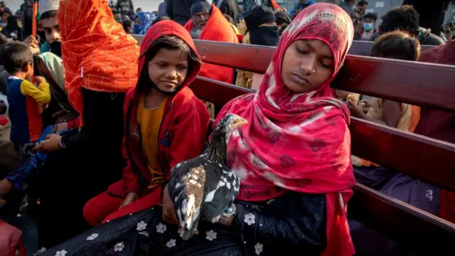 বাংলাদেশ নৌবাহিনীর জাহাজে নিজের মুরগী কোলে এক রোহিঙ্গা নারী। এ পর্যন্ত প্রায় ৯ হাজার রোহিঙ্গাকে ভাসানচরে নেয়া হয়েছে।