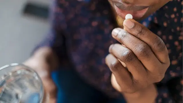 Femme qui prend une pillule