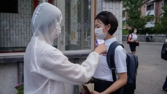 রাজধানী পিয়ংইয়ং-এ একজন শিক্ষার্থীর তাপমাত্রা পরীক্ষা করা হচ্ছে - মে ২০২২