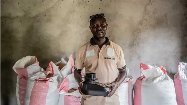 Koko Bikuba, ancien combattant de 37 ans, tient un réfractomètre pour mesurer la température du café.