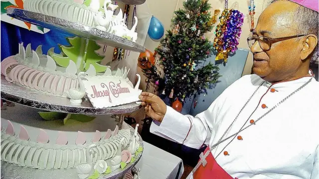 বড়দিনের কেক দেখছেন এক যাজক