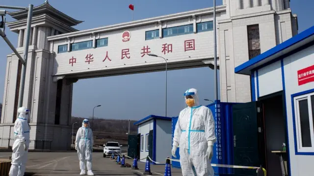 This photo taken on May 1, 2020 shows staff wearing hazmat suits as a precaution against the COVID-19 coronavirus waiting to check a truck at a customs checkpoint on the border with Russia at Suifenhe, in China's northeast Heilongjiang province.