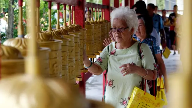 Buddhist devotees spin prayer wheels on Vesak Day at the Enlightened Heart Tibetan Buddhist temple in Ipoh, Malaysia May 29, 2018