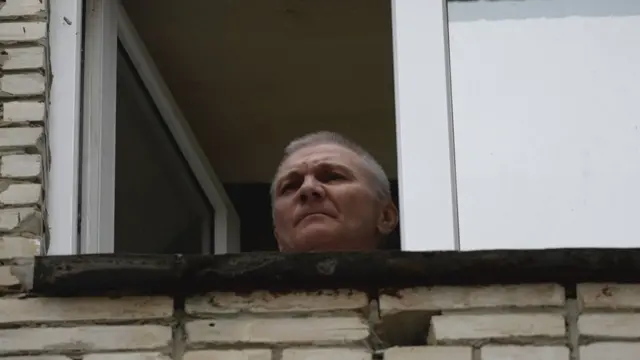 Alexei Moskaleva appears at a window of the building where he is being held under house arrest