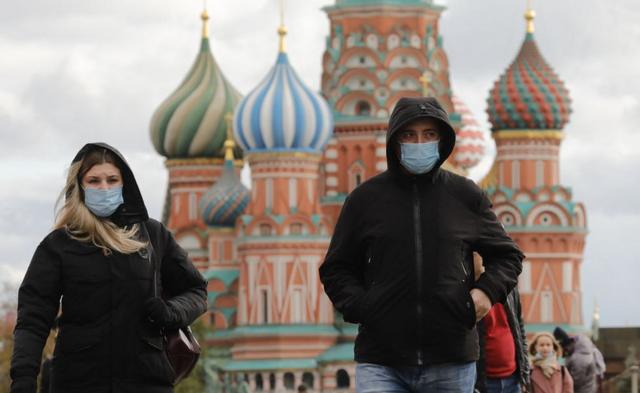 Personas caminan con mascarilla en el centro de Moscú.