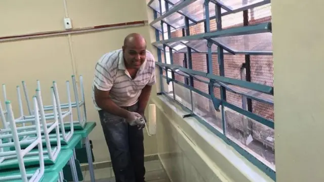 Diego Lima pintando a escola