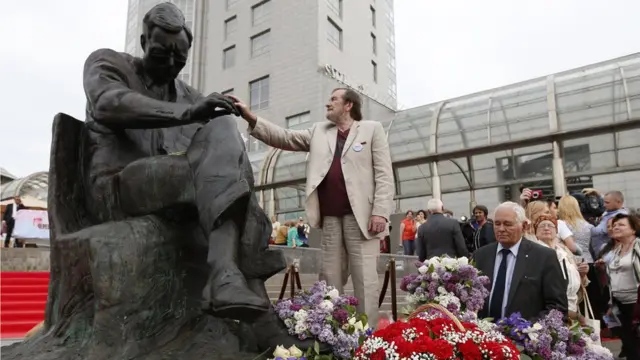 Максим Д. Шостакович стоит около памятника своему отцу Дмитрию Шостаковичу. 2015 год