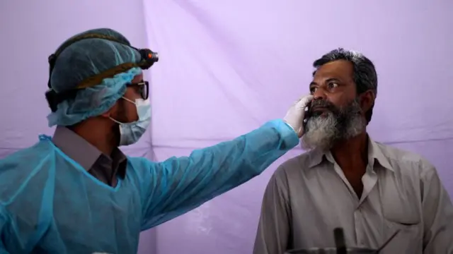 ঢাকায় একটি অস্থায়ী মেডিকেল ক্যাম্পে করোনাভাইরাসের উপসর্গ নিয়ে হাজির এক ব্যক্তিকে পরীক্ষা করা হচ্ছে