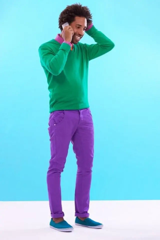 ชายหนุ่มถือโทรศัพท์และกำลังเกาศีรษะ