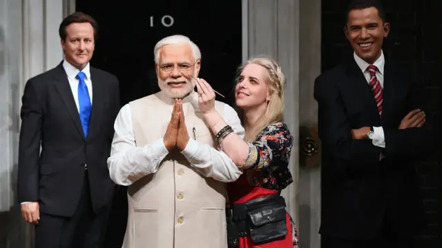 A Madame Tussauds artist puts the finishing touches on a wax figure of Narendra Modi as it joins figures of other world leaders in London, 2016.