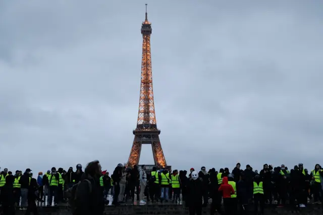 Protestors stand on the Trocadero esplanade in front of the Eiffel on December 8, 2018 in Paris, during a protest of "yellow vests" (gilets jaunes) against rising costs of living they blame on high taxes.