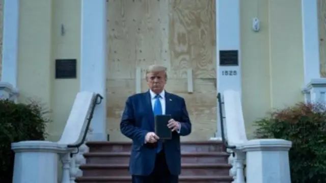 হোয়াইট হাউজের কাছে বিক্ষোভের সময় ক্ষতিগ্রস্ত একটি গির্জার সামনে বাইবেল হাতে দাঁড়িয়ে ডোনাল্ড ট্রাম্প