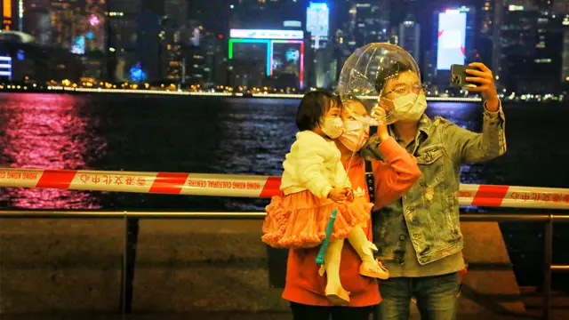 一家三口在尖沙咀維港旁合影留念。